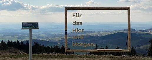 Foto mit Plakatrahmen aus Holz und Sitzbank in der Natur